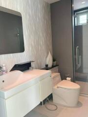 Modern bathroom with white vanity, mirror, toilet, and shower