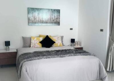 Modern bedroom with double bed, bedside tables, and wall art