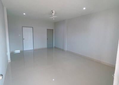 Spacious empty living room with ceiling lights and fan.