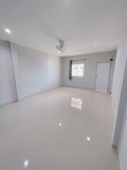 spacious empty living room with white walls and tiled floor