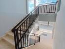 Staircase with black railings and tiled flooring