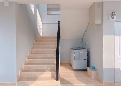 utility area with stairs and washing machine