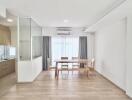 Bright dining area with a view of the kitchen and large windows.