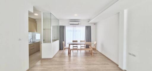 Bright dining area with a view of the kitchen and large windows.