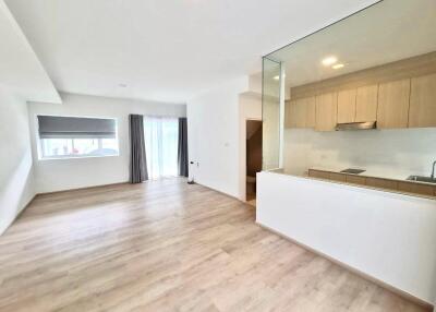 Spacious main living area with natural light and a kitchen view