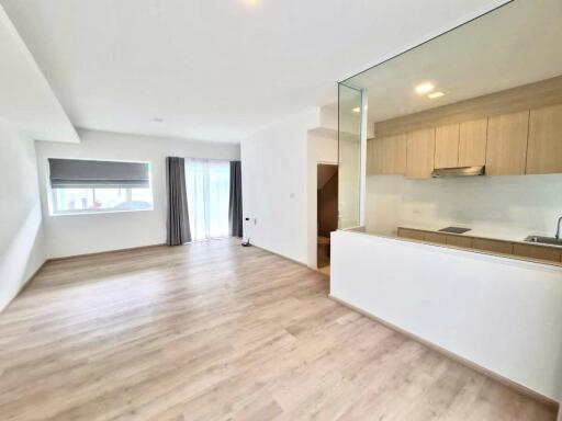 Spacious main living area with natural light and a kitchen view