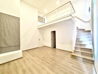 Spacious modern living room with a mezzanine level and staircase