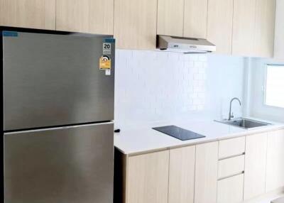 Modern kitchen with light wood cabinets and stainless steel appliances