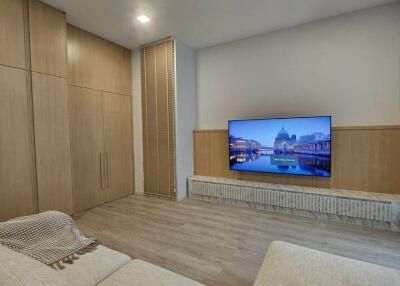 Spacious, modern living room with a large TV and built-in storage