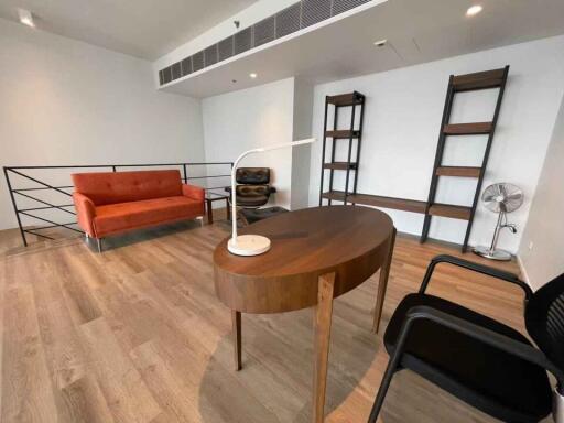 Modern living room with sofa, shelves, and a desk