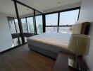 Modern bedroom with large windows and city view