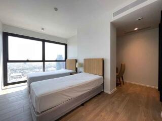 Modern bedroom with twin beds and a city view