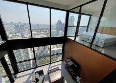 High-rise apartment with large windows, city view, and mezzanine bedroom