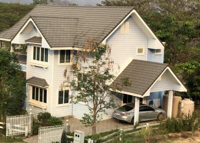 Two-story house with an attached garage and surrounding greenery