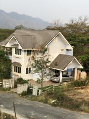 Two-story house with an attached garage and surrounding greenery