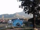 Blue house in a scenic rural area with a mountain backdrop