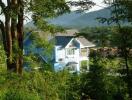 Blue house surrounded by greenery and mountains