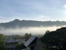 View of foggy mountains from a rooftop