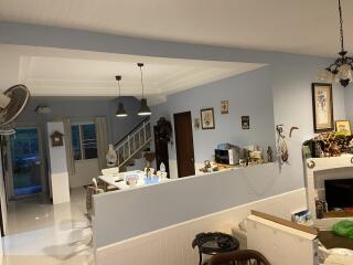 Living area with a partial view of the kitchen and staircase