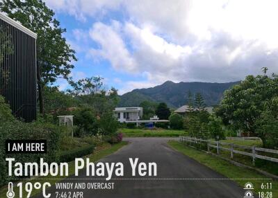 A picturesque residential neighborhood in Tambon Phaya Yen with lush greenery and mountains in the background.