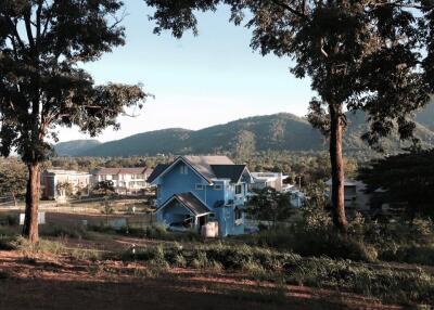 Scenic view of houses in a rural area with mountains in the background