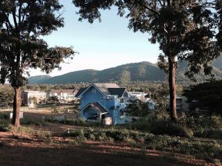 Scenic view of houses in a rural area with mountains in the background