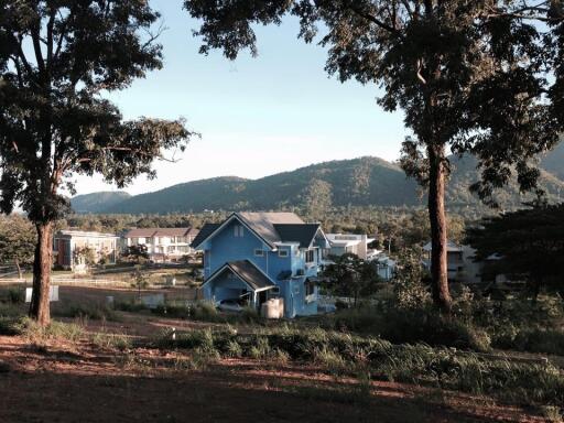 Scenic view of houses in a rural area with mountains in the background