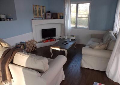 Cozy living room with natural light, couches, and TV