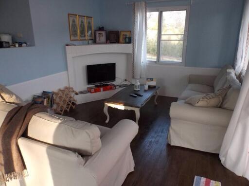 Cozy living room with natural light, couches, and TV