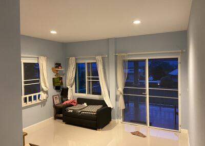 Cozy living room with a sofa, shelves, and large sliding windows