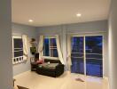 Cozy living room with a sofa, shelves, and large sliding windows