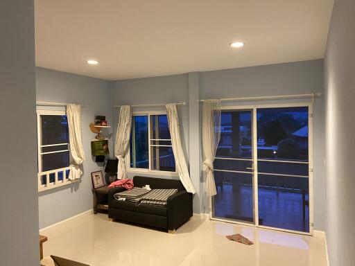 Cozy living room with a sofa, shelves, and large sliding windows