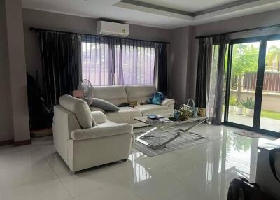 Spacious living room with large windows, modern furniture, and a view of the outside patio