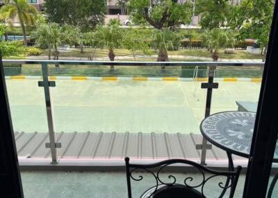 Balcony with a view of a swimming pool and garden