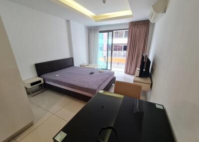 modern bedroom with a large bed, glass desk, and balcony view