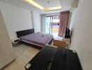 modern bedroom with a large bed, glass desk, and balcony view