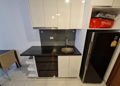 Modern compact kitchen with black countertops and stainless steel sink