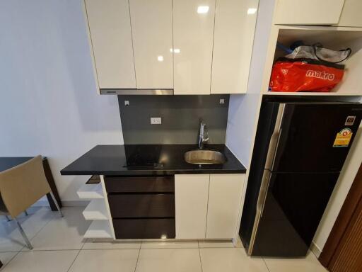 Modern compact kitchen with black countertops and stainless steel sink