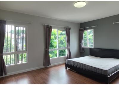 Spacious bedroom with large windows and a bed.