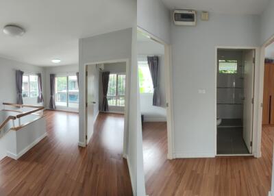 Main living area with staircase, adjacent bathroom, and large windows