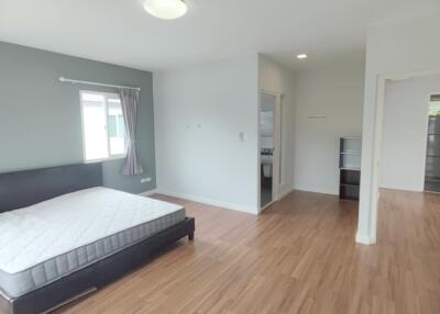 Spacious bedroom with wood flooring and adjacent bathroom