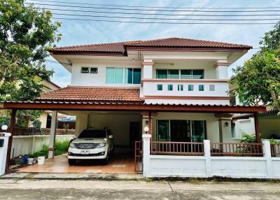 Front view of a two-story house with a driveway and carport