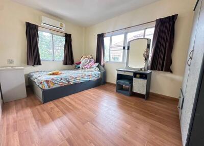 Bedroom with bed, vanity, and wooden flooring