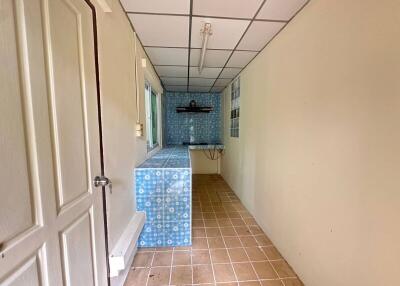 Narrow kitchen with blue patterned tiles and a window