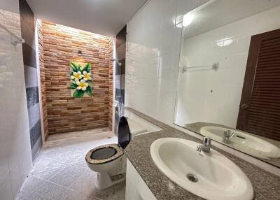 Bathroom with modern decor including stone brick wall and flower artwork