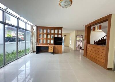 Spacious living room with large windows and built-in wooden entertainment unit