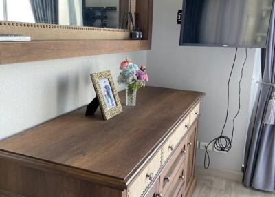 Bedroom with wooden dresser and mounted TV