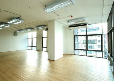 Spacious empty room with large windows and wooden flooring