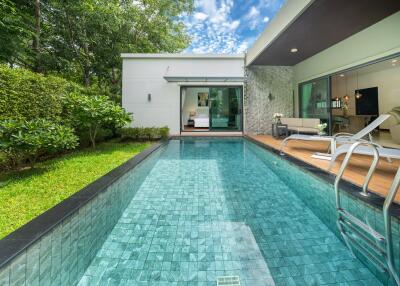 Outdoor pool area with lush greenery and connecting indoor spaces