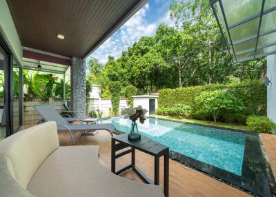 Outdoor seating area with swimming pool and lush greenery